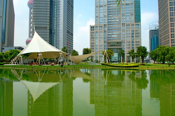 Reflection of skyscrapers and tent over lake — Stock Photo, Image