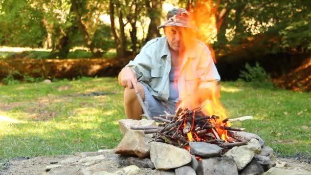 Hommes assis près du feu de camp — Video