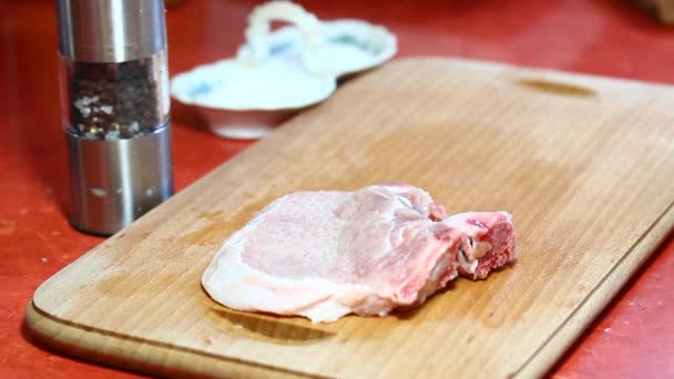 Женщина готовит свиную отбивную — стоковое видео
