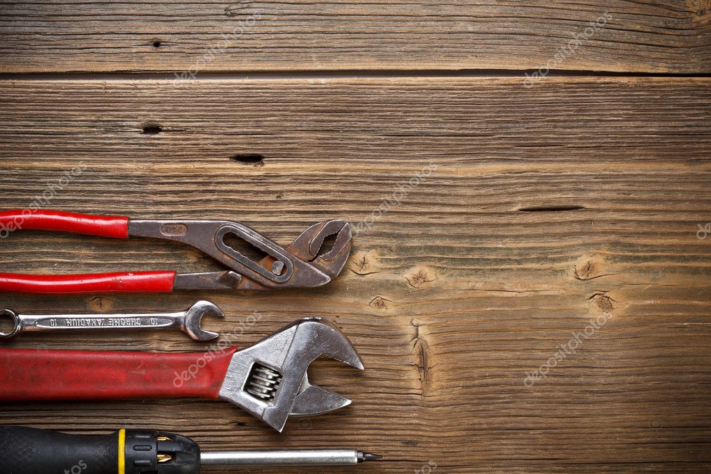 Инструменты для ремонта на старом деревянном фоне