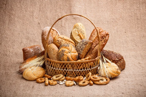 Pão e rolos em cesta de vime — Fotografia de Stock