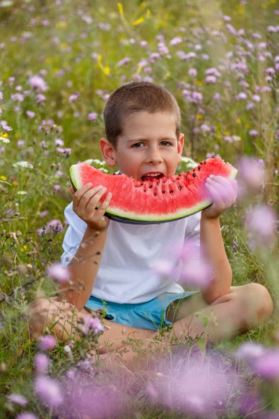 Pojke äter en vattenmelon — Stockfoto