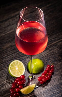 Ahşap arka planda kırmızı üzümlü içecek.