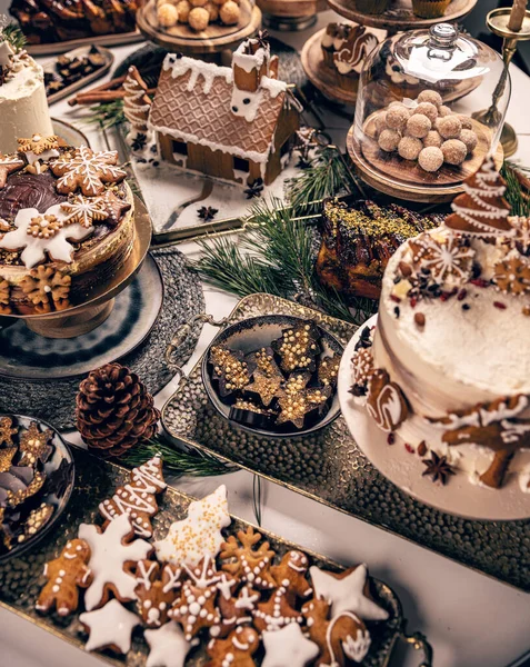 圣诞节甜点和糖果的餐桌 姜饼屋 蛋糕和饼干 — 图库照片