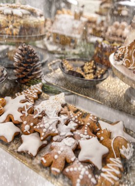 Farklı şekillerde bir sürü zencefilli kurabiye ve beyaz krema.