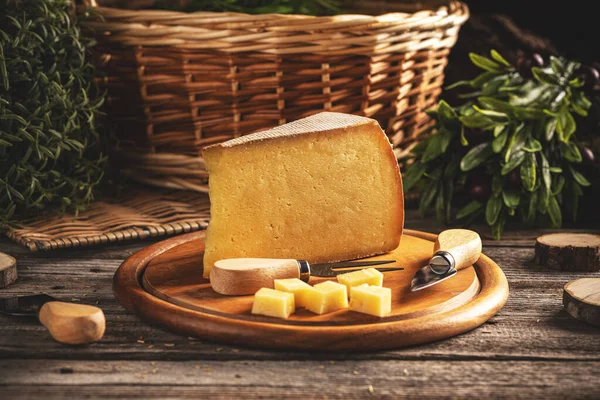 木製のまな板の上に黄色の長い熟成チーズのスライスとキューブ — ストック写真