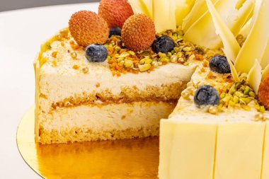 Şam fıstığı ve beyaz çikolatayla süslenmiş mascarpone kremalı ve tuzlu karamelli keki kapat.