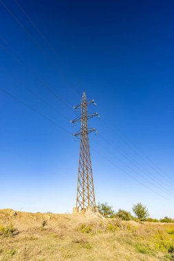 Yüksek voltaj direği veya elektrik kulesi yeşil alanda yüksek voltajlı iletim yeridir. Enerji teknolojisi kavramı