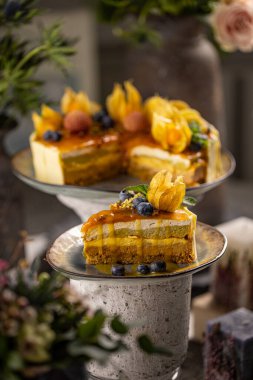 Üzümlü ve böğürtlenli, tuzlu karamel kaplı bir dilim şam fıstıklı kek.