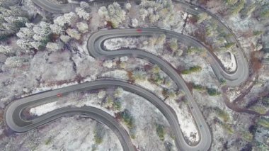 Romanya 'daki viraj yolunun havadan görünüşü. Arabalar orman içinde trafiğe çıkar.