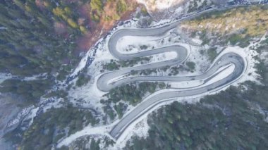 Kayalık dağ ormanlarındaki bir yılanın insansız hava aracı görüntüsü, Bicaz vadisi kış mevsiminde dolambaçlı yol ile, Cheile Bicazului, Romanya