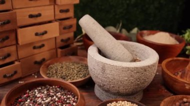 Tahta kaselerdeki aromatik baharatlar havanda ezilmeye hazır.