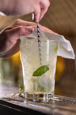 Barmen mojito kokteyli hazırlıyor. Uzun içki konsepti