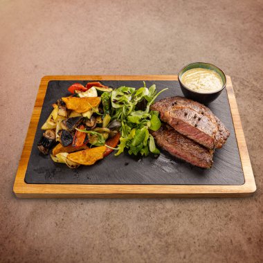 Kızarmış sebze ve hardal soslu marulla süslenmiş kemiksiz domuz pirzolası.