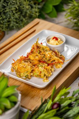 Beyaz tabakta servis edilen mayonezli sebzeli börek. Endonezya mutfağı.