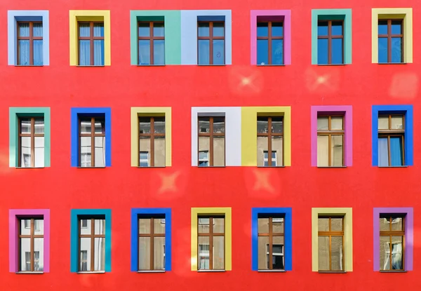 Red facade with colourful windows — Stock Photo, Image