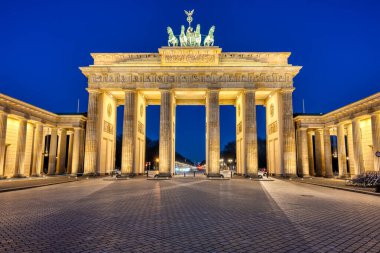 Berlin 'deki ünlü Brandenburg Kapısı alacakaranlıkta aydınlandı.