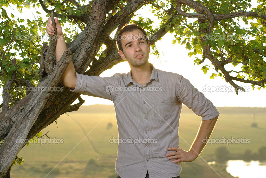 Guy under tree on field