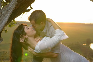 iki sevgilisi alanı ağacının altında öpüşme