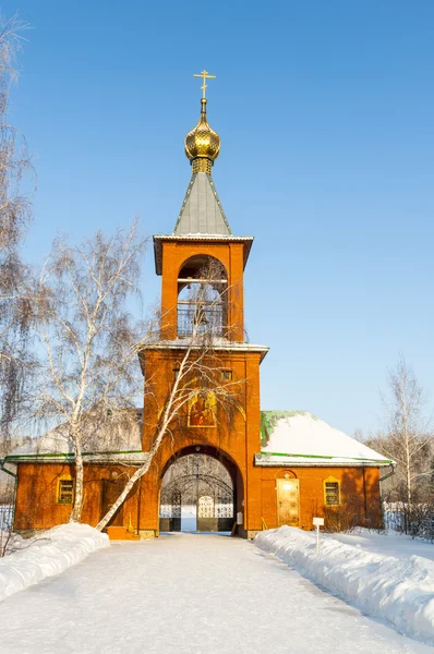 Iglesia ortodoxa en un campo cubierto de nieve — Foto de Stock