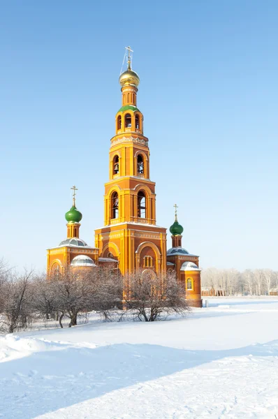 Iglesia ortodoxa en un campo cubierto de nieve — Foto de Stock