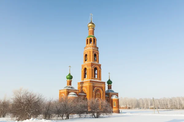 Iglesia ortodoxa en un campo cubierto de nieve — Foto de Stock