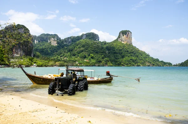 Loading of products from a boat on the shore of the tractor on a tropical Thai island — Stock Photo, Image
