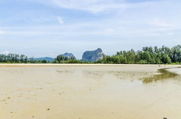 La marea oceanica sulla spiaggia sabbiosa in Thailandia su uno sfondo di rocce — Foto Stock