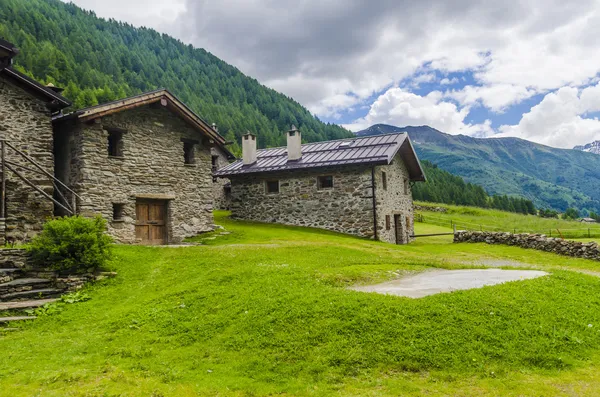 Kamenný dům pastýře v rolnické vesnice v alpské louky obklopené horami. severní Itálie — Stock fotografie