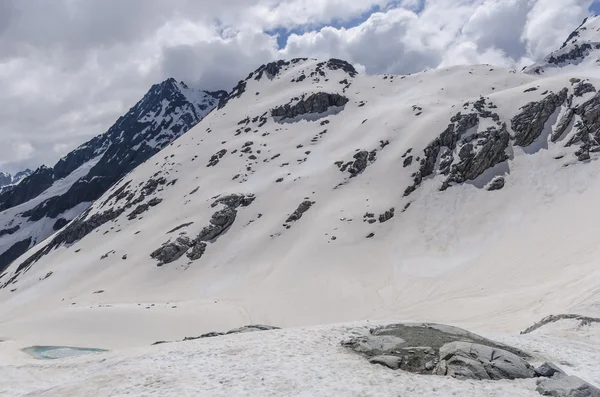Derretimiento de glaciares y rocas en la cima de una montaña a una altitud de 2400 metros en los Alpes italianos —  Fotos de Stock