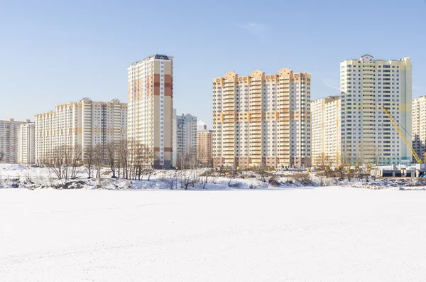 Opførelsen af nye beboelsesejendomme i Moskva på baggrund af et vinterlandskab . - Stock-foto