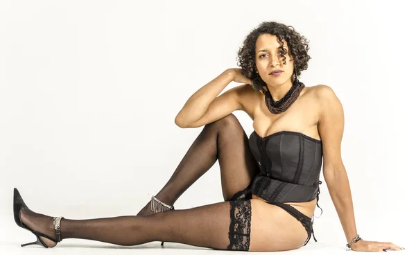 Beautiful young mulatto woman in black lingerie and stockings — Stock Photo, Image