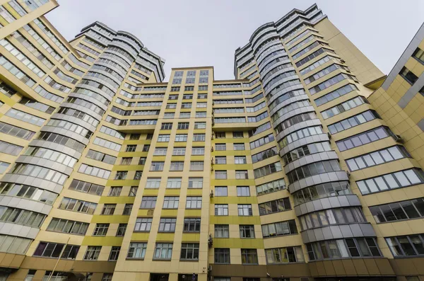 Modernes mehrstöckiges Wohnhaus mit Wohnungen und Balkonen. Fassaden, die sich in die Höhe strecken. — Stockfoto