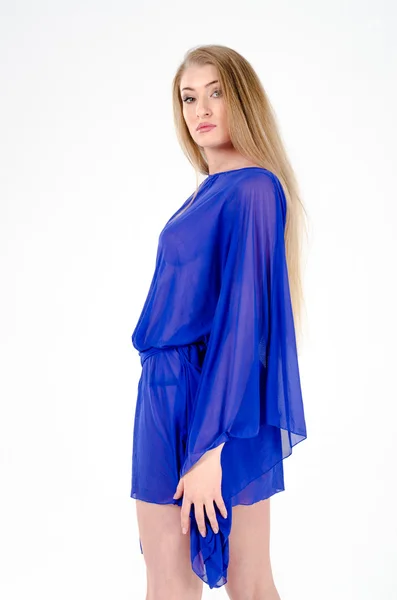 Beautiful long-haired blonde in a clear blue tunic and blue shoes — Stock Photo, Image