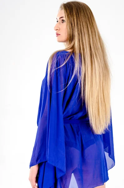 Beautiful long-haired blonde in a clear blue tunic and blue shoes — Stock Photo, Image