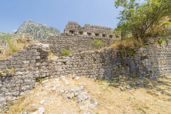 Ciudad amurallada de San Juan en la ciudad de Kotor. Las murallas de la ciudad en las montañas y las escaleras subiendo. Ruinas de viejo muro — Foto de Stock