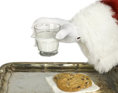 Noel Baba el sütü çikolatalı kurabiye ile tutarak