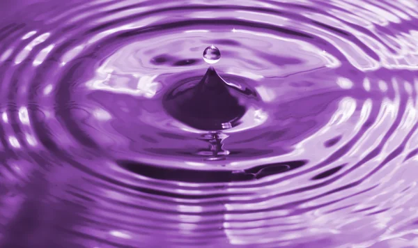 Colorato goccia d'acqua viola e spruzzi — Foto Stock