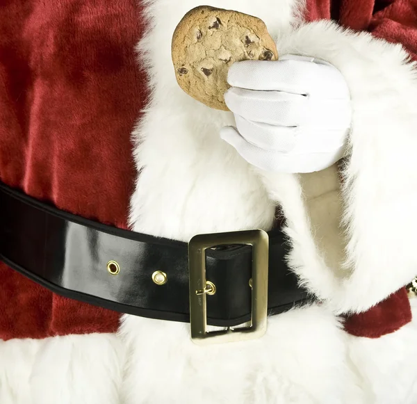 Santa claus hand met een chocolade chip cookie — Stockfoto