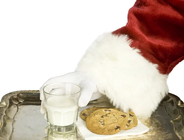 Santa claus ruka drží mléko čokoláda čip cookie — Stock fotografie