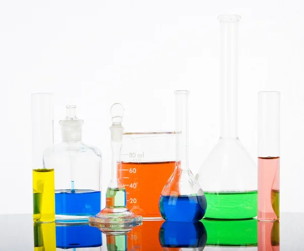 Laboratory glassware on white background with reflections — Stock Photo, Image