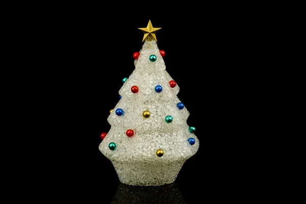 Weißer Weihnachtsbaum mit Ornamenten aus recyceltem Kunststoff isoliert auf schwarz Stockfoto