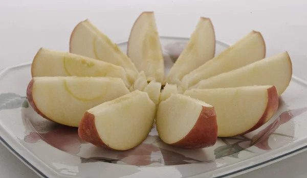 Cuts apple on a plate — Stock Photo, Image