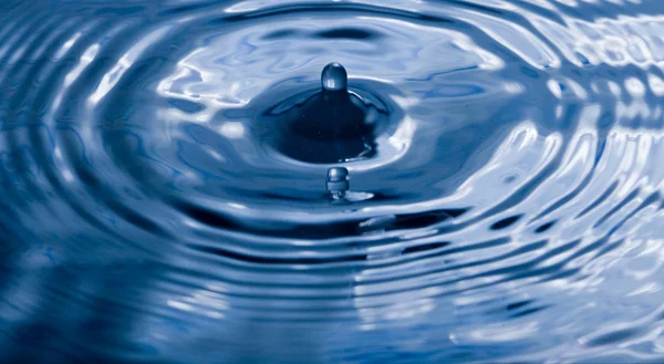 Druppel blauw water en splash. — Stockfoto