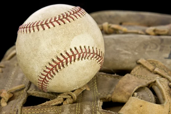 Slitna läder baseball handsken håller en baseball — Stockfoto