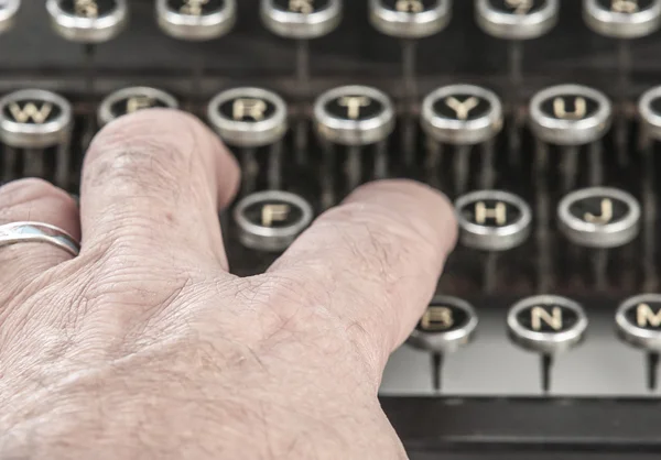 Palce na vintage maszynę do pisania na biały — Zdjęcie stockowe