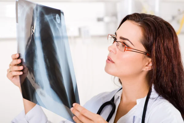 Joven doctora mirando la radiografía de la paciente — Foto de Stock