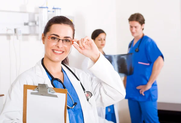 Feliz trabajadora de la salud en la sala de hospital con sus colegas — Foto de Stock