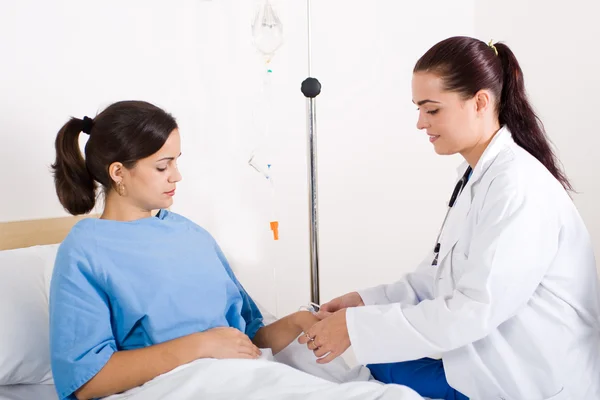 Caring doctor helping hospitalized patient with iv drip — Stock Photo, Image