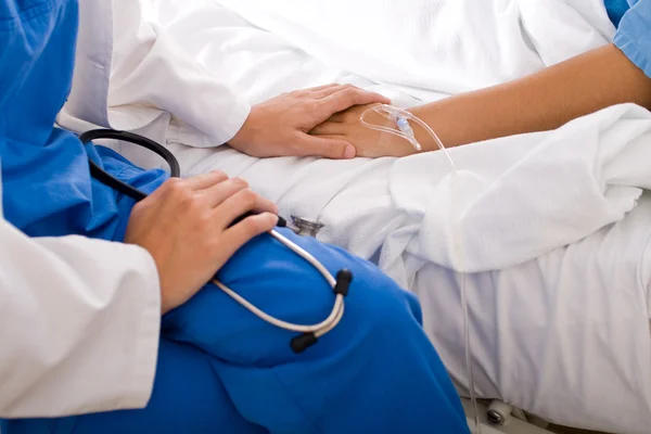 Заботливый врач утешает госпитализированного пациента — стоковое фото